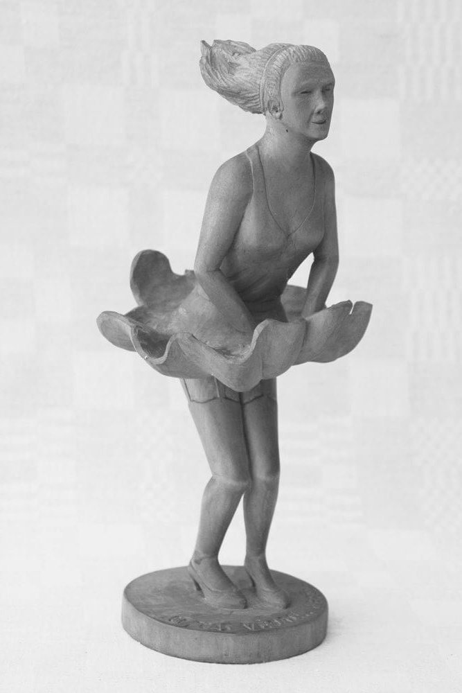 Statulėlė ('Oi, tas, vėjas, begėdis'. Vaizduoja moterį, prilaikančią sijoną, 1996 m. h - 25,8 cm.)