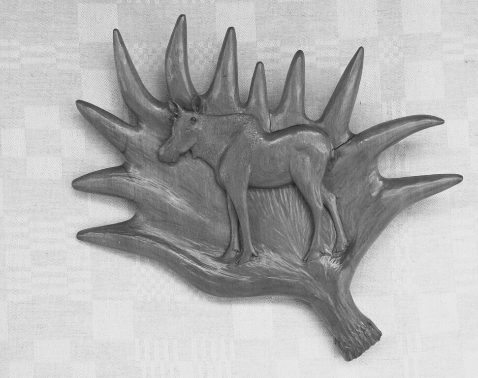 Reljefas (medinis, 'Briedis', pagrindas rago formos, ant jo išskaptuotas briedis, 1983 m., 33 x 31,5 cm.).