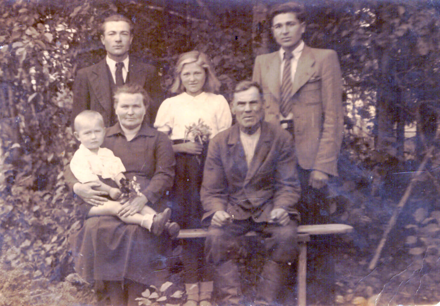 Anykščių rajono Sedeikių kaime. Pirmoje eilėje sėdi iš kairės Domicėlė Žiūkienė su anūku Leonu Apšega ir senelis Jurgis Žiūkas. Antroj eilėje iš kairės krikšto tėvas dėdė Petras Žiūkas, teta Damutė ir dėdė Jonas. 1944 m.